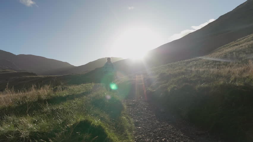 Female Hiker walking  through sun flares
