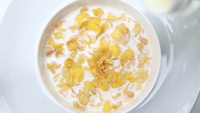 Pour the milk into the white bowl with the cornflakes or cereal. Quick and easy healthy meals in the morning.