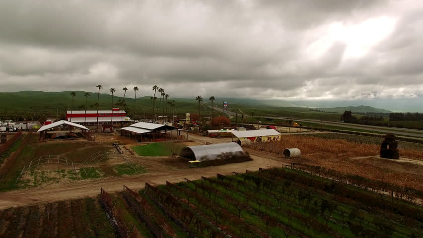Aerial: Drone Forward Scenic Shot Of Structures In Tranquil Field On Hills Under Cloudy Sky - Bakersfield, California