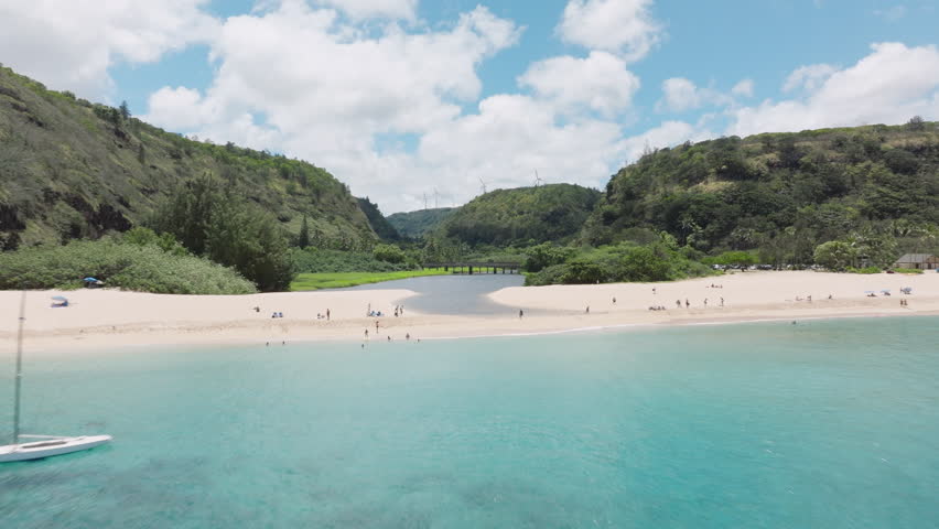 Cinematic aerial Waimea Bay Beach on sunny summer day. People enjoy vacation on beautiful sandy beach. Scenic nature landscape of Hawaii island. Waimea Valley panorama on Oahu North shore USA travel