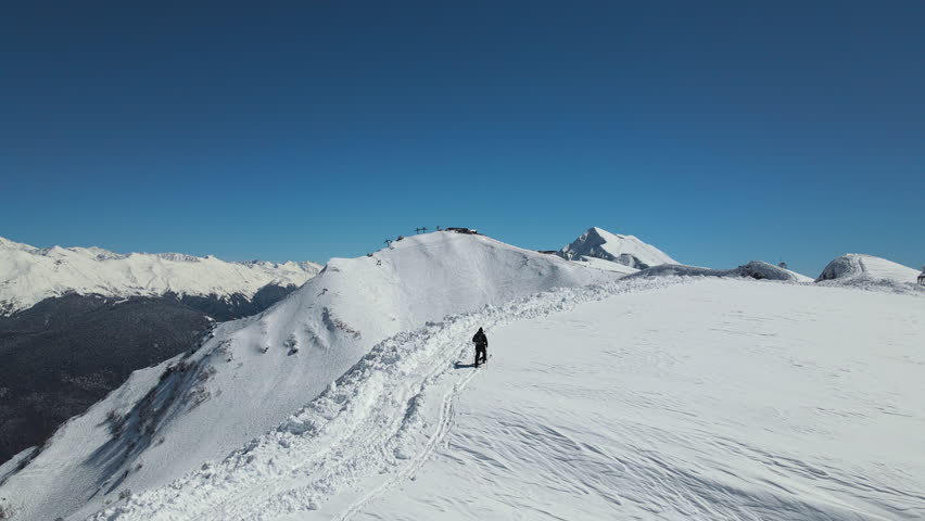 View of a man skiing against the backdrop of snow-capped mountains. Ski tour