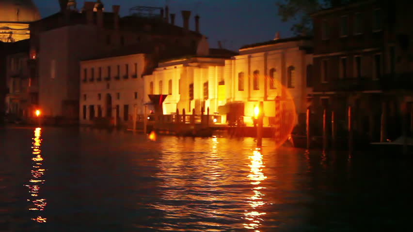 Approaching large structures of Venice by boat at night
