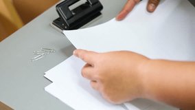 Hands clipping papers together on a desk