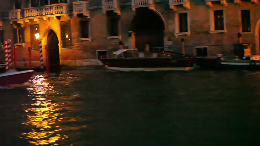 Passing by buildings with decorated pillars while boating through Venice at
