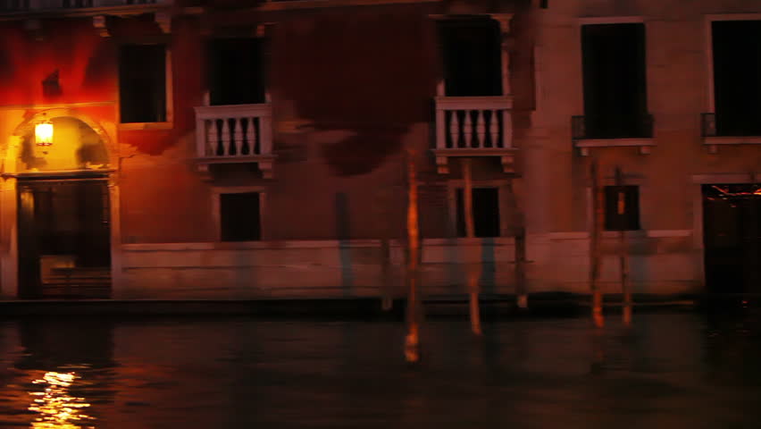 Passing a boat and a well lit lamp post in a Venice waterway