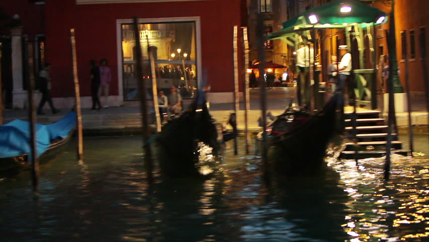 Fast shot floating past docked gondolas at night