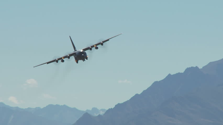 A C130 Hercules in flight heading towards camera and banking from left to right