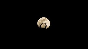 A striking scene unfolds as the full moon passes through the crescent moon emblem of a Muslim temple, set against a pitch-black background - Powered by Shutterstock - Get 15% off with code: PIKWIZARD15