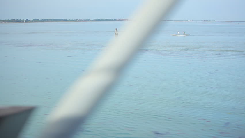 Tracking shot of ocean from train window between Rome and Venice. Boats and