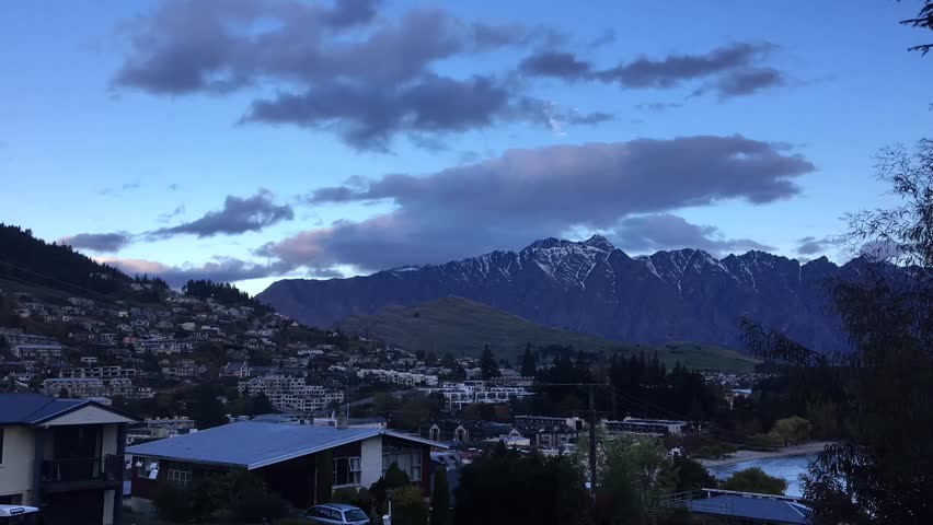 Clouds move over the snowy peaks of the mountains at new zealand