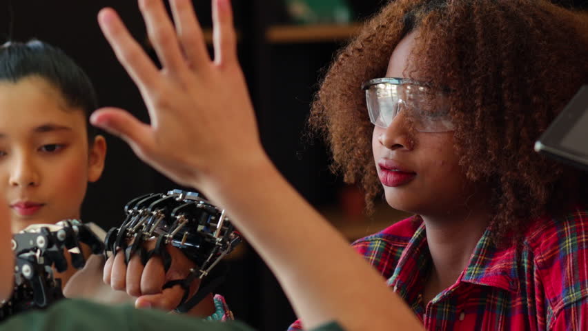 Happy african american girl and diverse teens students group building robotic  hand using laptop computer. Building And Learning To Program electric Robot. STEM coding engineering class. - Powered by Shutterstock - Get 15% off with code: PIKWIZARD15