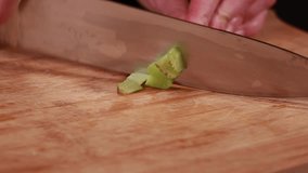 woman hands cutting, chopping celery close-up on wooden board