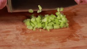 woman hands cutting, chopping celery close-up on wooden board