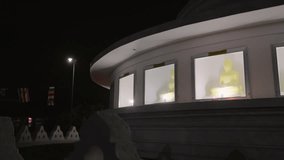 Buddhist temple lit at night, serene atmosphere as statues of Buddha glow softly. Spiritual sanctuary offers peace, meditation space, cultural exploration and religious practice in moonlight. - Powered by Shutterstock - Get 15% off with code: PIKWIZARD15