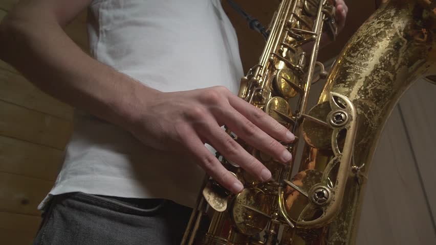 A student in a white T-shirt rehearses the saxophone jazz improvisations at home Royalty-Free Stock Footage #3442812923