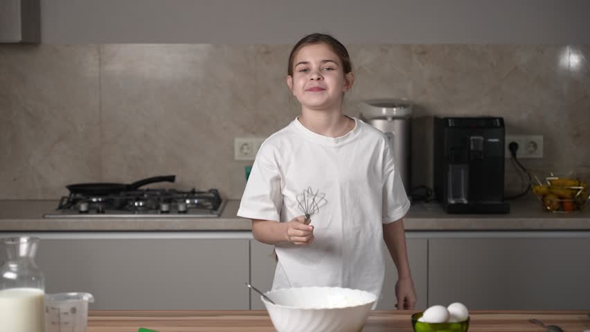 Girl having fun, dancing, singing karaoke and enjoying time on family kitchen at home on women's day. Smiling child cooking, making dough for pancakes for breakfast. Royalty-Free Stock Footage #3442814511