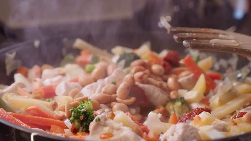Peanuts added to chicken, vegetables: Cooking curry in hot saucepan Royalty-Free Stock Footage #3442865005