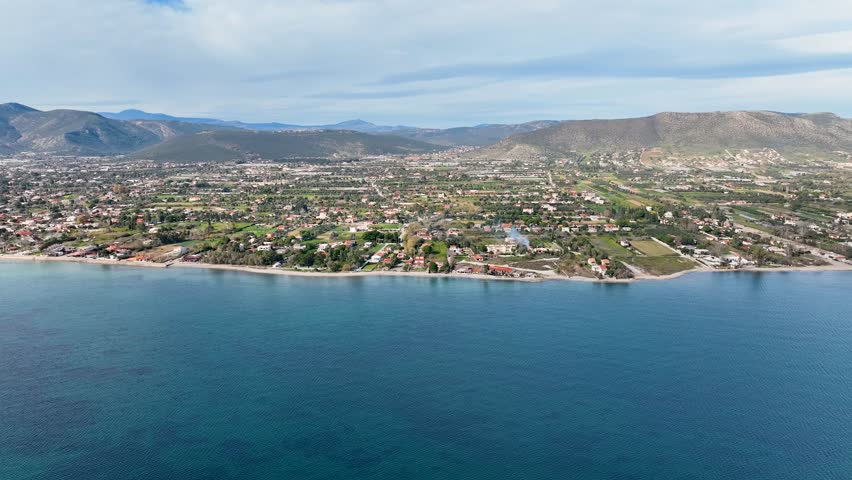 Flying towards the coastline with houses and agricultural land