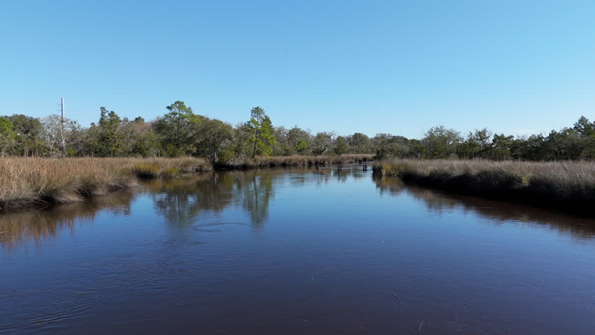 Aerial footage following the water of a river in southern Georgia with blue skies.
