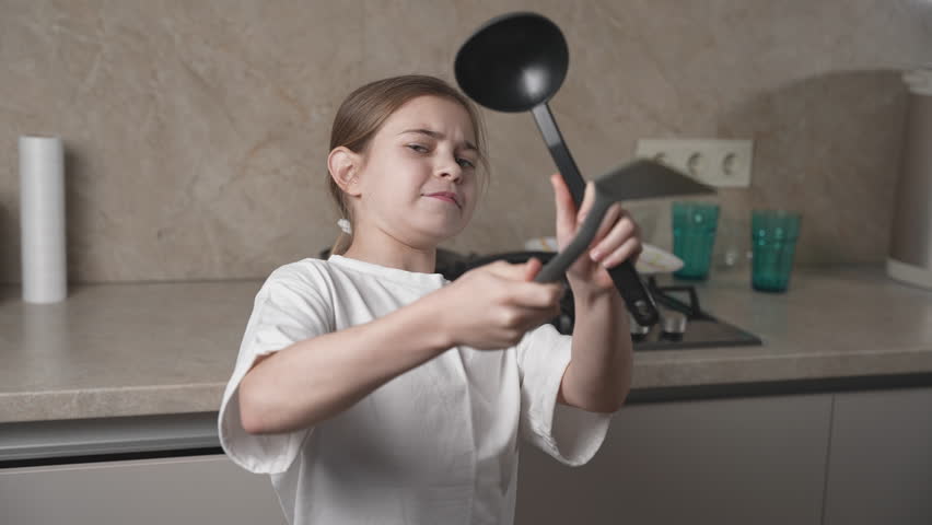 Girl having fun, dancing, singing karaoke and enjoying time on family kitchen at home on women's day. Smiling child cooking, making dough for pancakes for breakfast. Royalty-Free Stock Footage #3442912015
