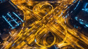 Aerial view of traffic on massive highway intersection at night.