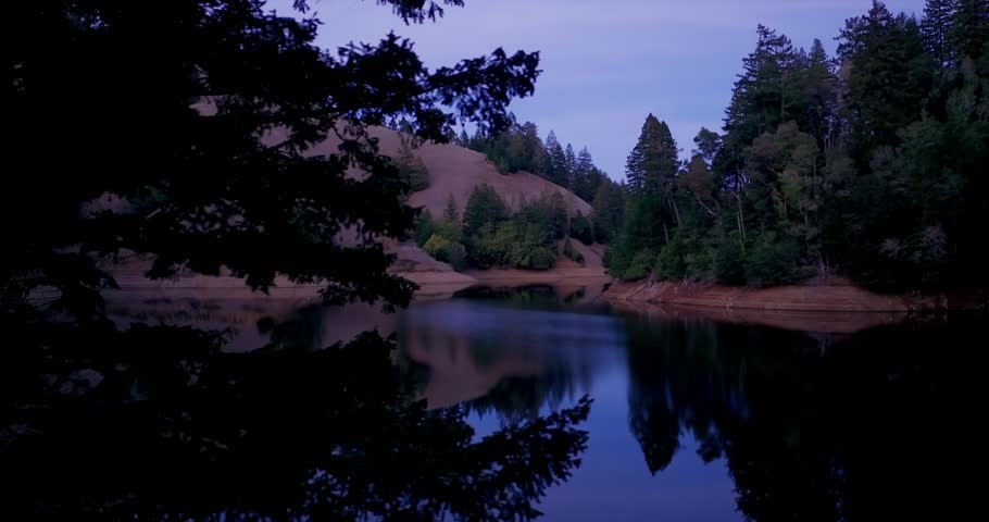 Aerial: Hills and forest around Alpine Lake reservoir at night in Marin County near San Francisco, California, USA
