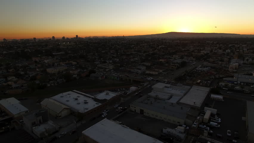 Aerial Downward Scenic View Of Buildings In City By Mountains Against Sky At Sunset - Long Beach, California