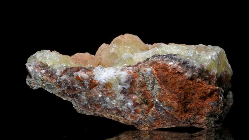 Greenish yellow Smithsonite (zinc carbonate) crystals rotating slowly against a black background