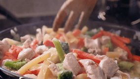 Wooden fork stirs chicken and vegetable stirfry in kitchen saucepan - Powered by Shutterstock - Get 15% off with code: PIKWIZARD15