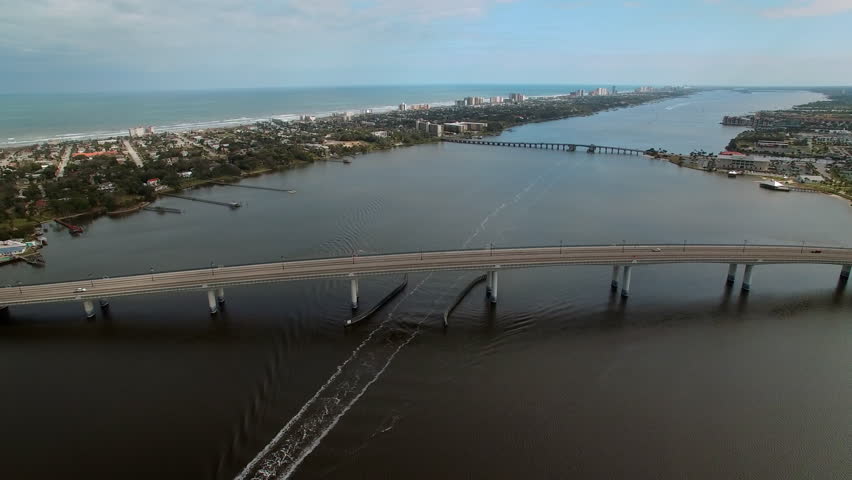 Aerial Backward Scenic View Of Bridges Over Halifax River In Residential City On Sunny Day - Daytona Beach , Florida