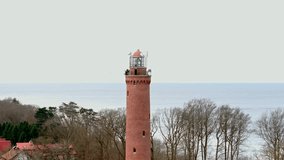 Lighthouse in Gąski by the Baltic Sea, in West Pomeranian Voivodeship, Poland. Winter landscape captured by drone.