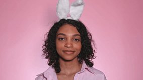  pink easter footage with cute happy girl in bunny ears winking and showing ok sign aprroving choice. promotion and advertisment concept - Powered by Shutterstock - Get 15% off with code: PIKWIZARD15