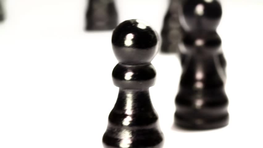 Black chess pieces crossing in a row. Close up
