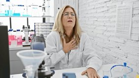 Unwell middle age blonde scientist coughing, likely a cold or bronchitis, in lab - health care alert - Powered by Shutterstock - Get 15% off with code: PIKWIZARD15