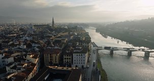 Aerial view of the Arno river in the cityscape of Florence, Italy. The architecture of the historical quarter on the banks of the river with bridges connecting the two banks. High quality 4k footage
