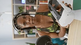 African american woman with braids wearing headphones in a studio holding virtual reality headset