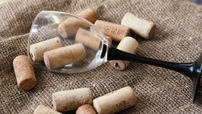 overturned empty glass goblet and wine bottle corks on textured fabric rotation. wine tasting, wine production, alcoholism concept - Powered by Shutterstock - Get 15% off with code: PIKWIZARD15