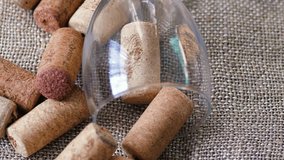 empty overturned glass wine goblet and wine bottle corks on fabric textured rotation. wine cellar, alcohol addiction, wine making - Powered by Shutterstock - Get 15% off with code: PIKWIZARD15