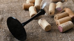 an empty overturned wine glass surrounded by a pile of wine bottle corks on a textured canvas fabric, rotation. concept alcohol addiction, drinking wine, sommelier test - Powered by Shutterstock - Get 15% off with code: PIKWIZARD15
