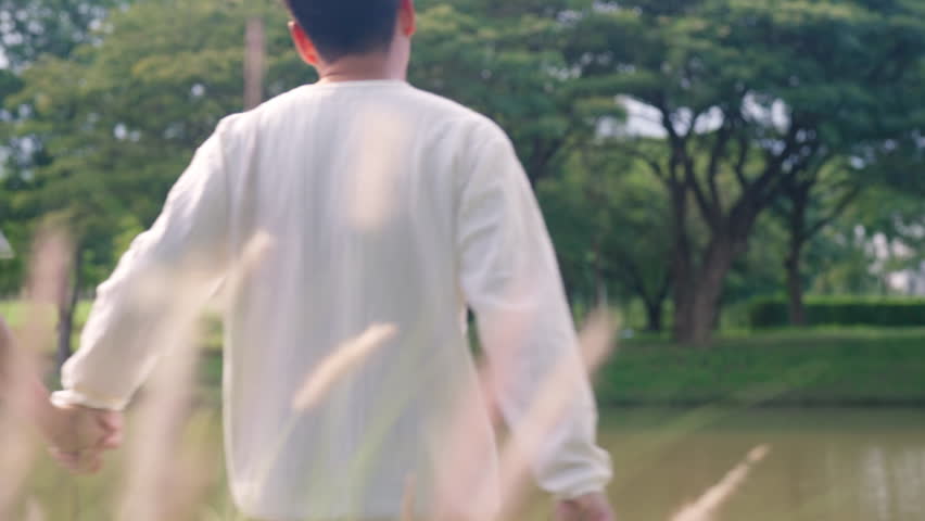 Young adult asia people happy lover flirt at public nature park falling in love desire kiss hug beloved care trust. Sweet asian lovers tender face to face man woman smile relax warm time date day.