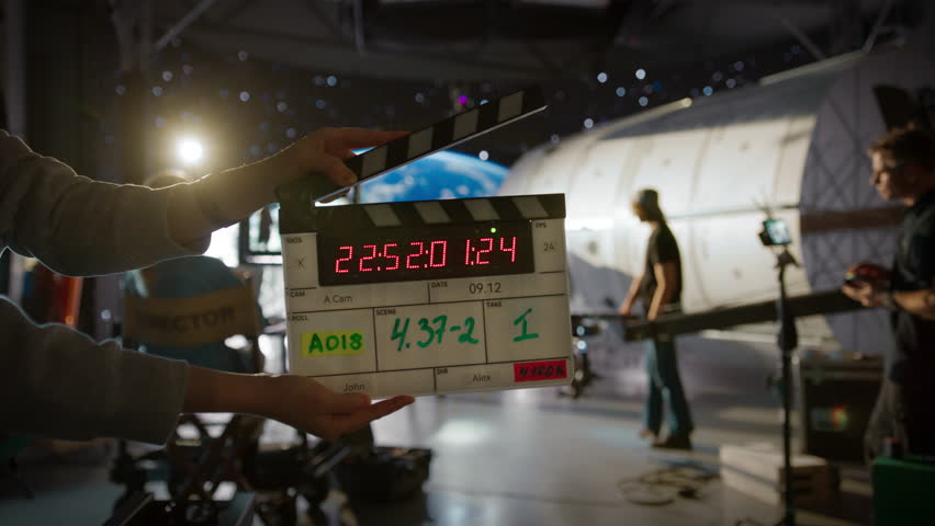 Female Directing a Movie Sequence with an Astronaut in Open Space. Studio with Virtual Production Screen Showing CGI Imagery with Planet Earth and a Practical Effect Mock Up of a Satellite Royalty-Free Stock Footage #3443333971