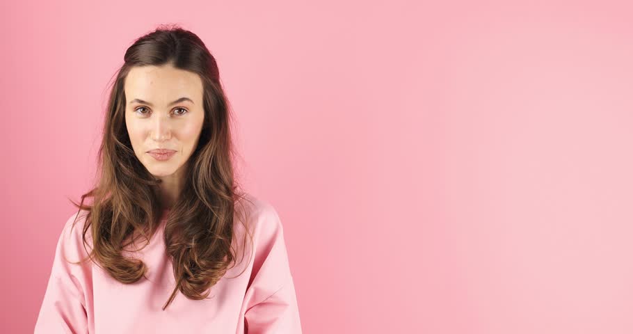 Excited surprised woman look at side, say wow and pointing hands aside isolated on pink background. Brunette girl in pink top. Look over here. Sale here. Royalty-Free Stock Footage #3443395799