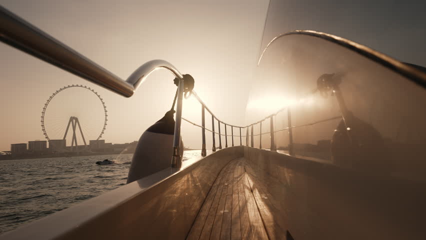 Ain Dubai ferris wheel view from a luxury yacht sailing in Persian Gulf in United Arab Emirates during a scenic sunset