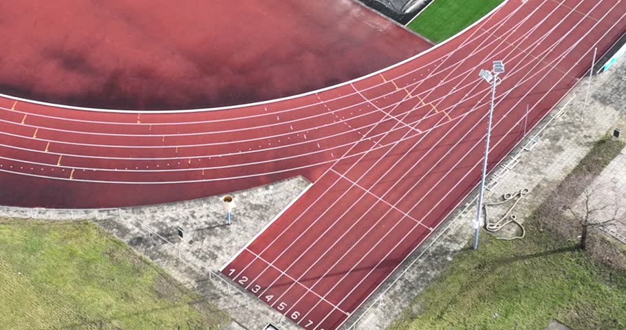 Birds eye aerial drone view of a detail of a running track, athletic course competion track. Field for excersise training and leisure activity.