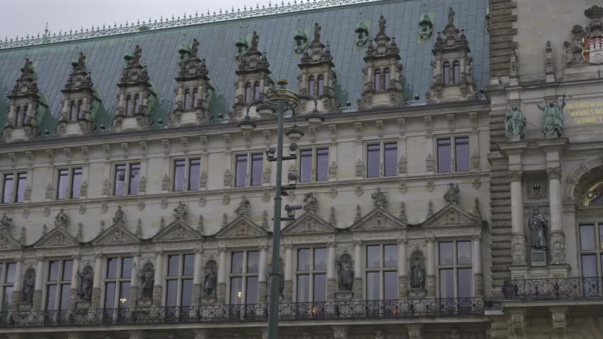 Hamburg, Germany. Square and city hall building in wet weather. Facade of municipal mairie in Hamburg. Hamburger Rathaus. Mayors office tower. Town hall. Hamburgischen Burgerschaft. 