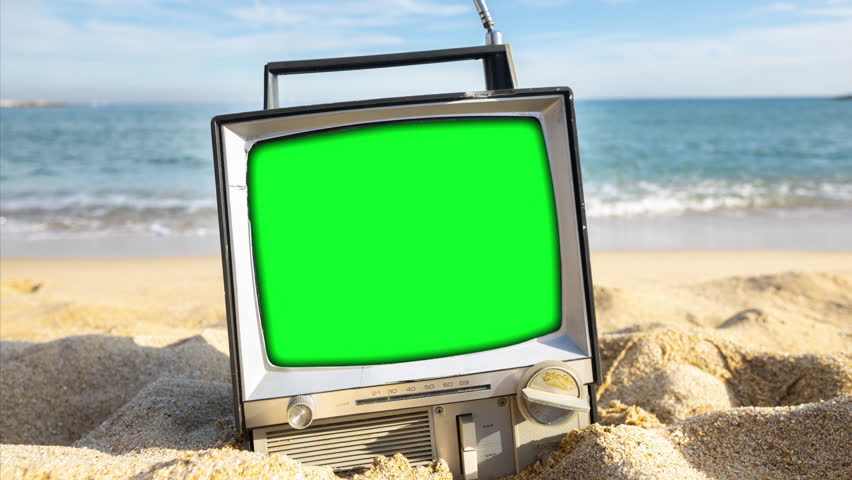 timelapse of a retro television and green screen for your own projects on a beach next to the sea