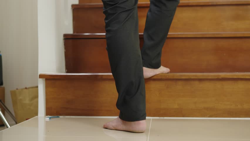 Footage tilt up shot, Foots of Retirement man walked up the stairs in house