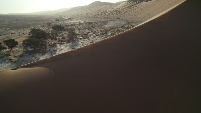 Girl on top of a sand dune in Namibia