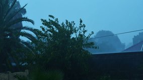 A 4K video of a Heavy downpour rainstorm with wind gushing from side to side with a very gloomy depressing coloring. Causing alot of damage and floods