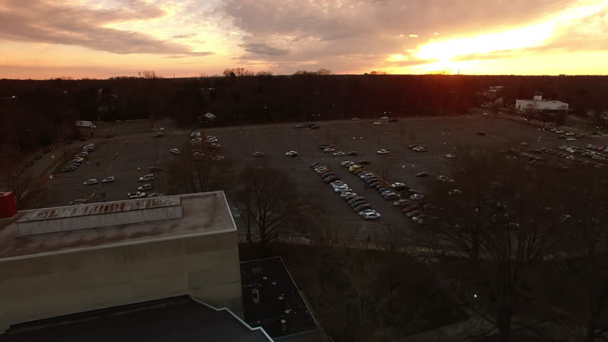 Aerial Shot Of Cars Parked In Parking Lot In Residential City, Drone Flying Forward Over Under Cloudy Sky At Sunset - Charlotte, North Carolina